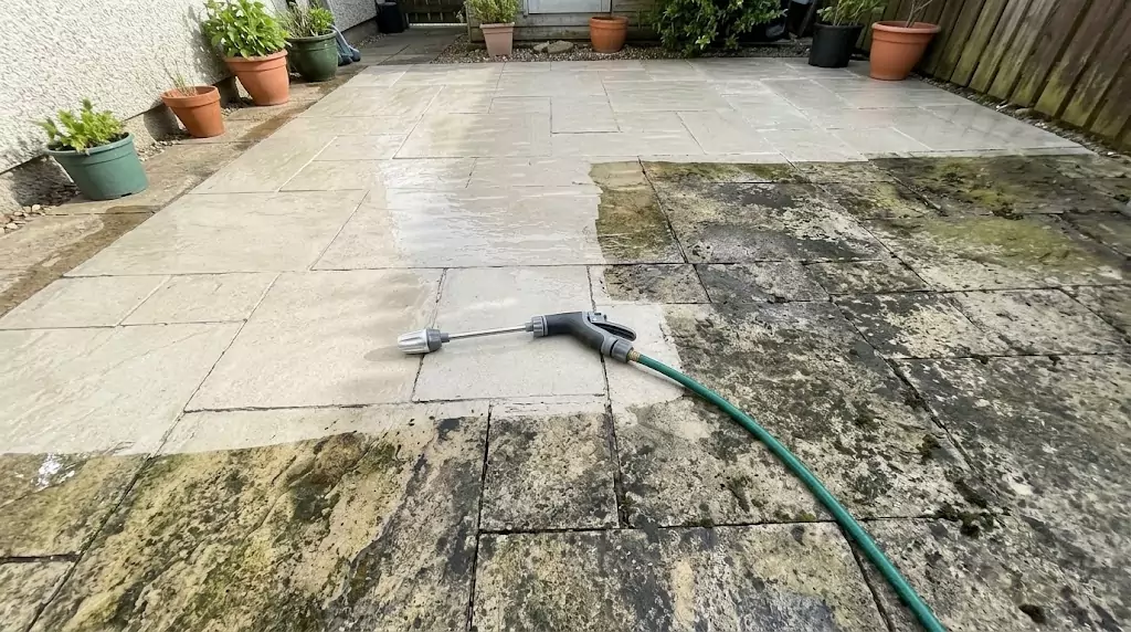 Jetterix test on a 32-m² stone patio — clear line between cleaned and uncleaned section